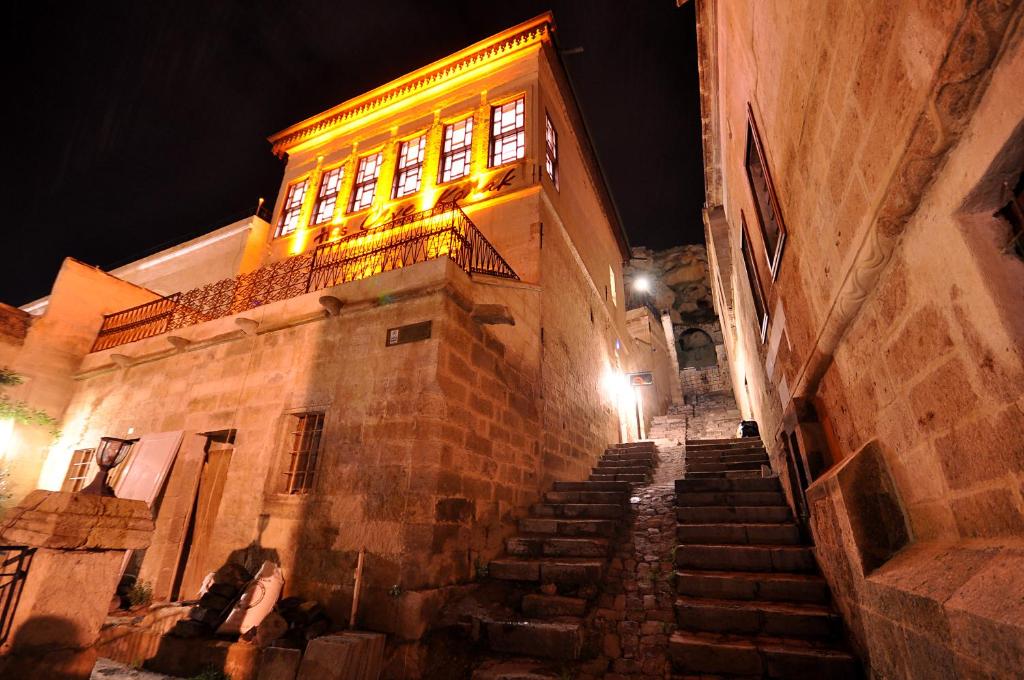 un antiguo edificio con escaleras en un callejón por la noche en Has Cave Konak, en Ürgüp