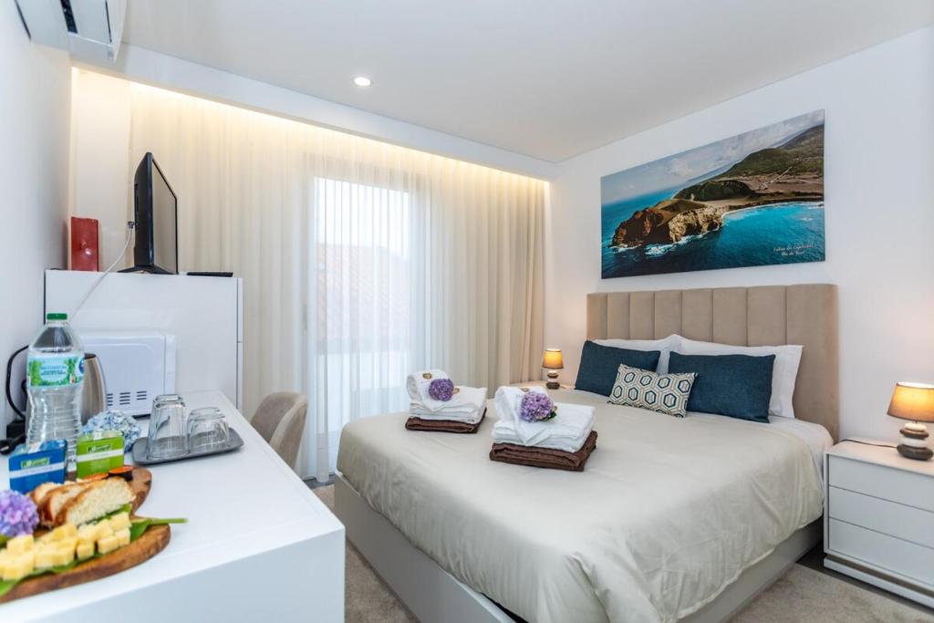 a bedroom with a bed and a table with food on it at GuestReady - Passal Guesthouse in Ponta Delgada