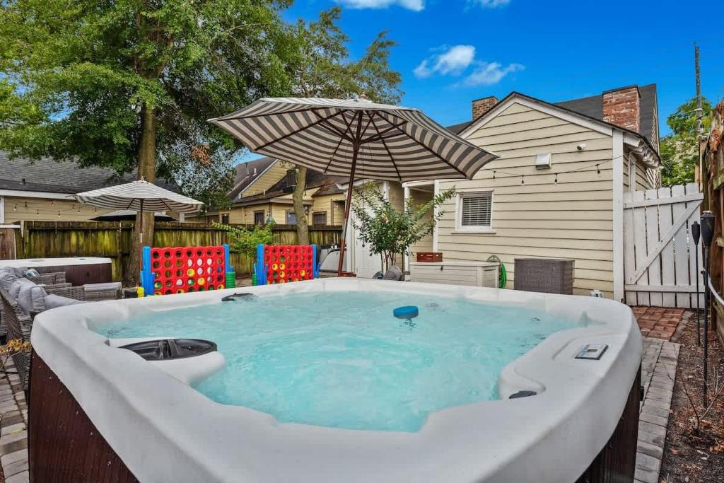 una vasca idromassaggio in un cortile con ombrellone di Hot Tub - Historic District - Next to Forsyth Park a Savannah