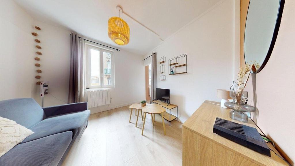 un salon avec un canapé bleu et une table dans l'établissement Rue Guillemard Studio, au Havre