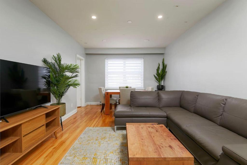 Una sala de estar con un sofá y un televisor. en Awesome 2BR in Montreal, en Montreal