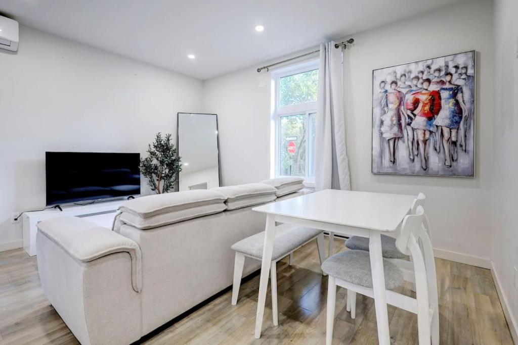 a living room with a white couch and a table at The NDG Escape Prime Location and Cozy Stay in Montréal