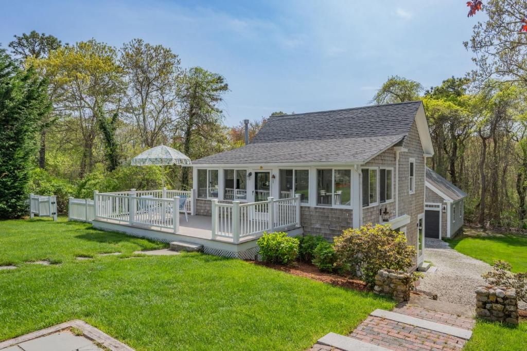 a small house with a large deck in a yard at 89 Gorham Road Harwich Port - Sweet Retreat in Harwich Port