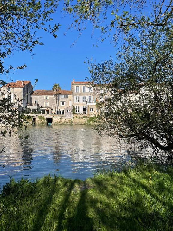 une vue sur une étendue d'eau avec des bâtiments dans l'établissement Gîte La Bergeronnette, à Saint-Savinien