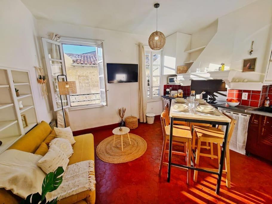 un salon avec un canapé et une table et une cuisine dans l'établissement HenRi - 5 minutes de la Gare à pied - Climatisation - Wi Fi, à Avignon