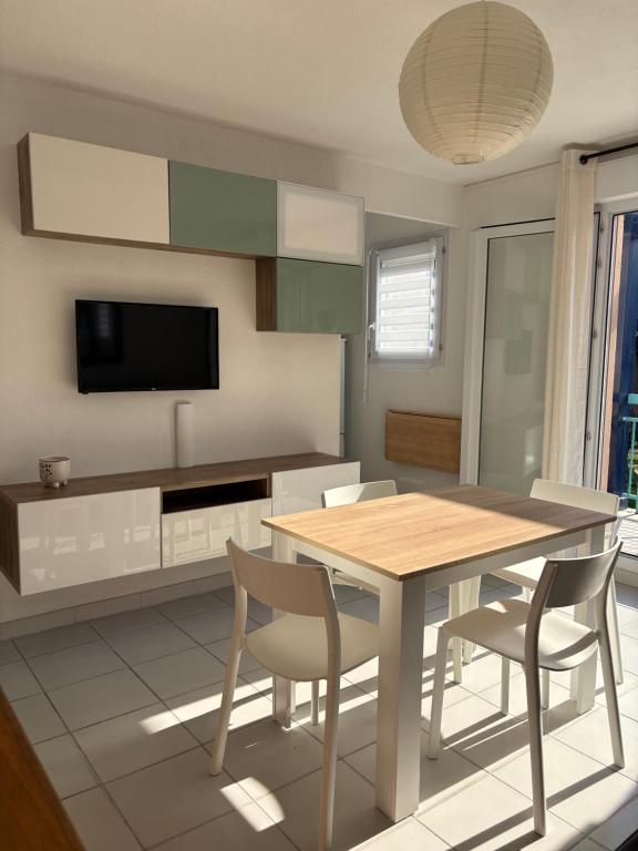 - une cuisine avec une table à manger et des chaises dans l'établissement Appartement cosy à 200 m de la plage à pied, à La Londe-les-Maures