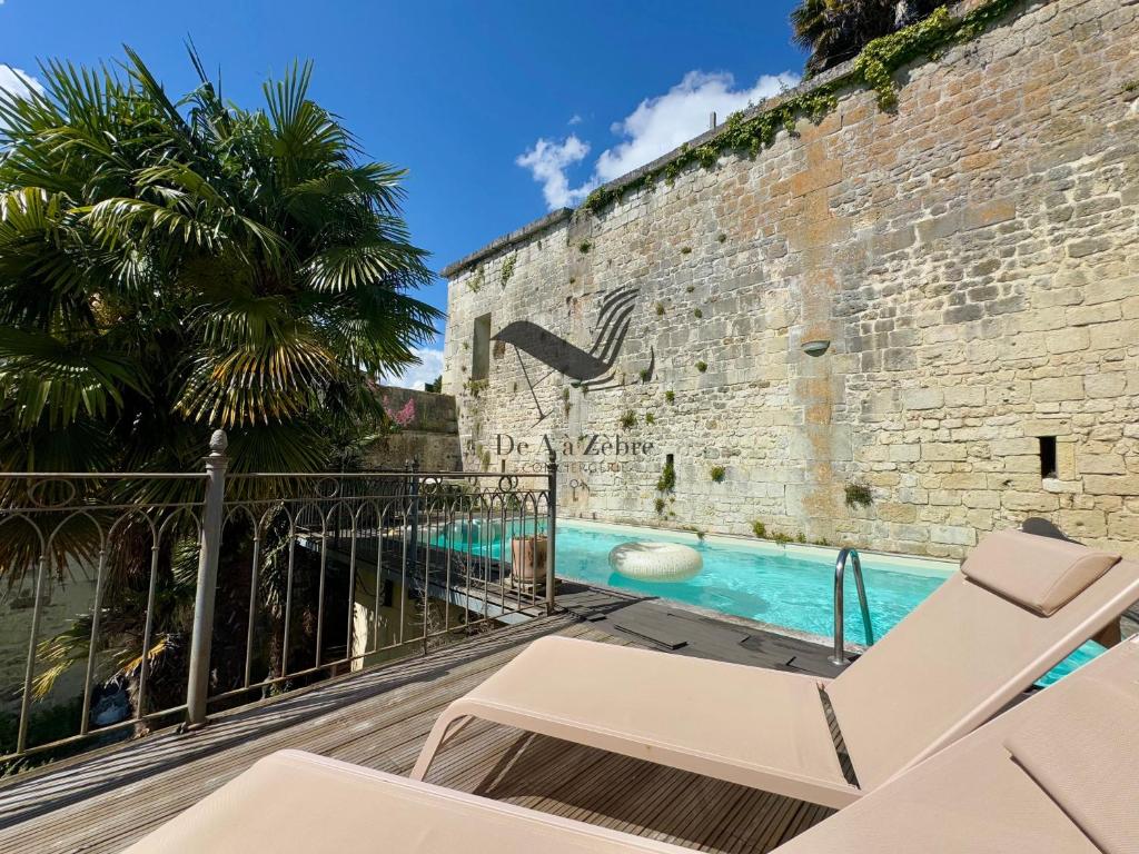 - une vue sur la piscine depuis le balcon d'un bâtiment dans l'établissement Maison M - Spacieuse maison avec piscine privative, à Tonnay-Charente