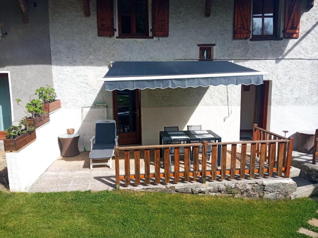 une maison avec une terrasse dotée d'un auvent bleu dans l'établissement Le Chavannaclub, à Allevard