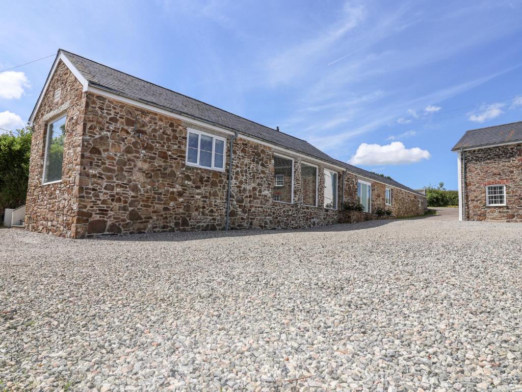 a brick building on a gravel driveway at Old Orchard Barn in Saltash