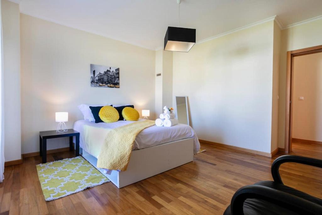 a bedroom with a bed with yellow pillows on it at GuestReady - Casa do Parque in Ponta Delgada
