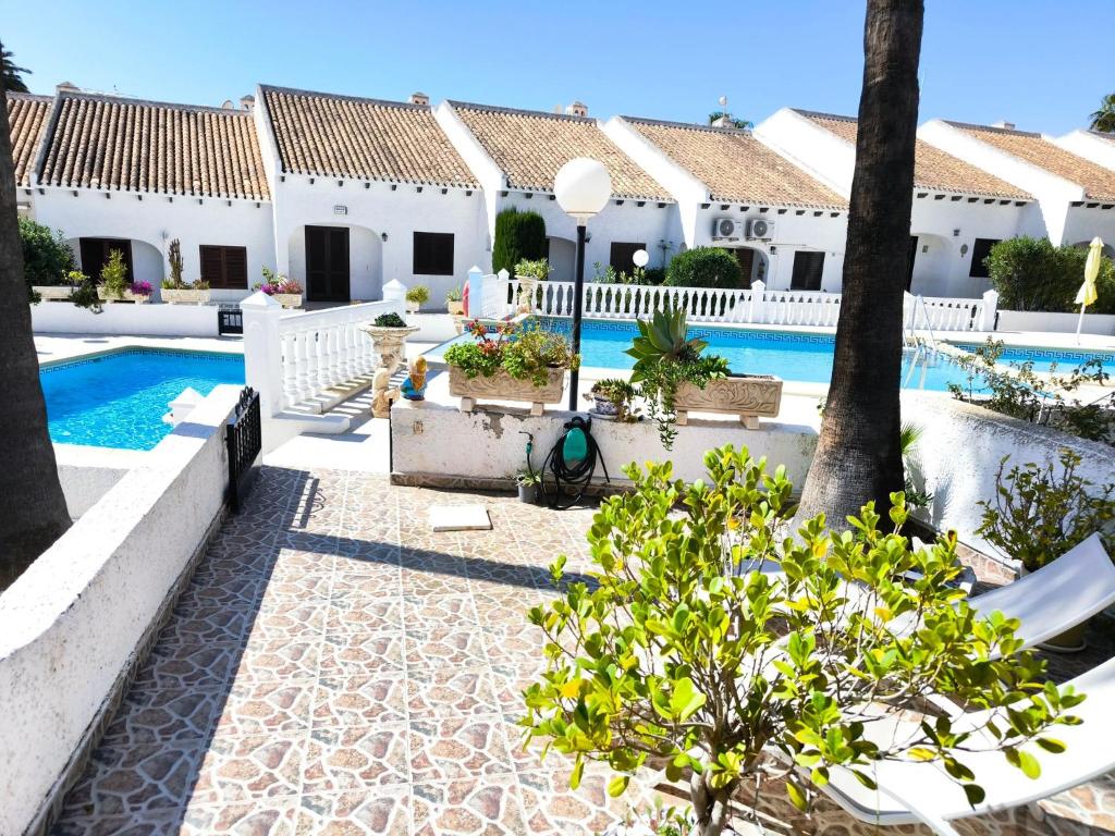 een villa met zwembad en een resort bij Bungalow at Cala Capitn Beach, Cabo Roig in Cabo Roig