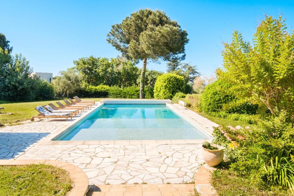 - un jardin avec une piscine entourée de chaises longues dans l'établissement Le Mas Des Serens, à La Gaude