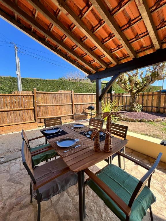 une table et des chaises en bois sur une terrasse dans l'établissement La maison d'Alice, à Sarlat-la-Canéda