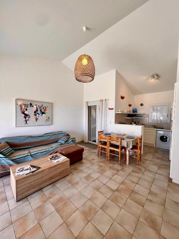 un salon avec un lit et une table dans l'établissement Logement A Nepita splendide vue mer avec piscine, à Porto-Vecchio