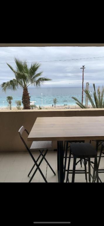 une table et des chaises avec vue sur la plage dans l'établissement Charme, à Cannes La Bocca