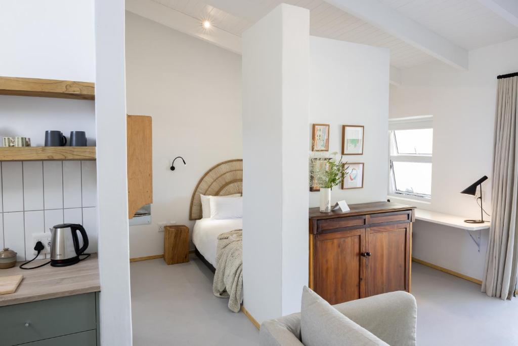 Stillewe Guest Cottages في Prince Alfreds Hamlet: غرفة نوم بها سرير ومكتب ومغسلة