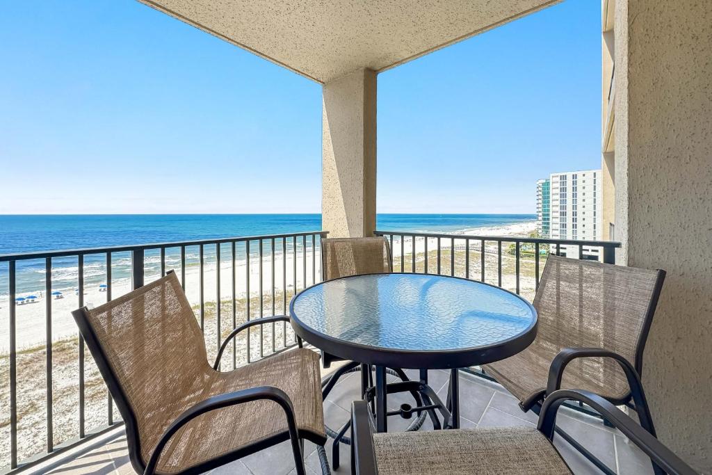 a balcony with a table and chairs and the beach at Phoenix X Unit 803 in Orange Beach