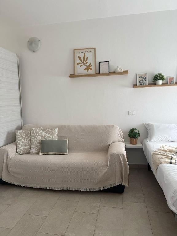 a living room with a couch and a bed at A due passi dal mare - OpenSpace in Porto Garibaldi