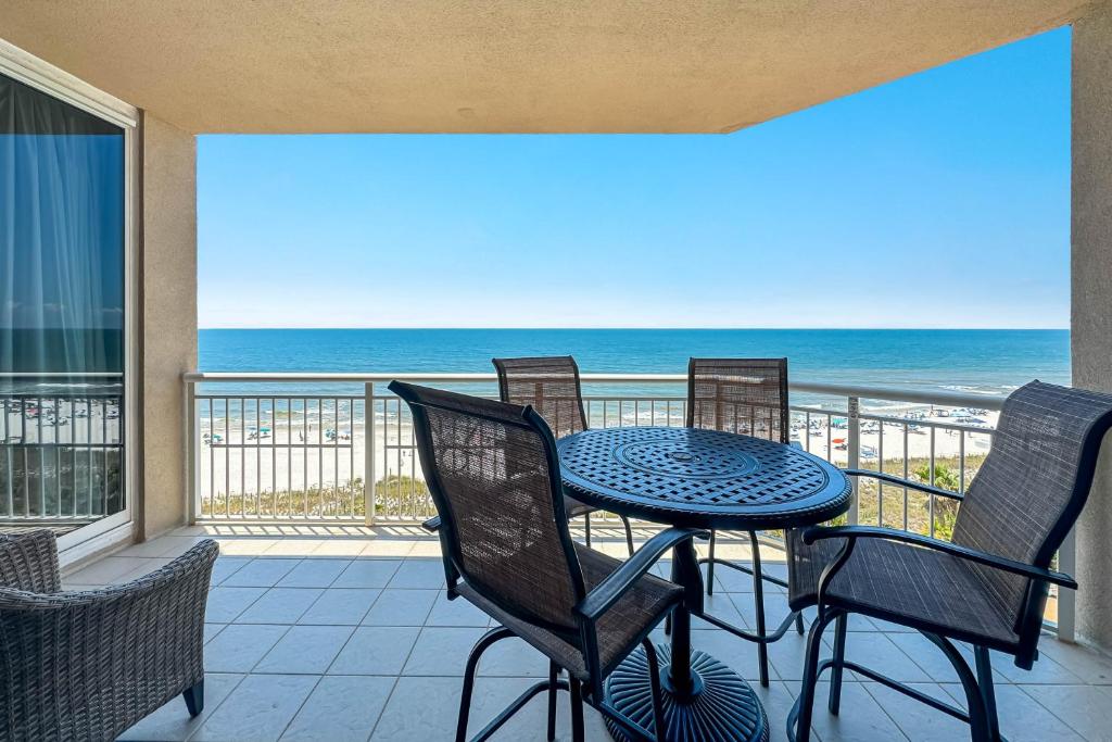 un tavolo e delle sedie su un balcone con vista sull'oceano di Indigo Unit 702E a Pensacola