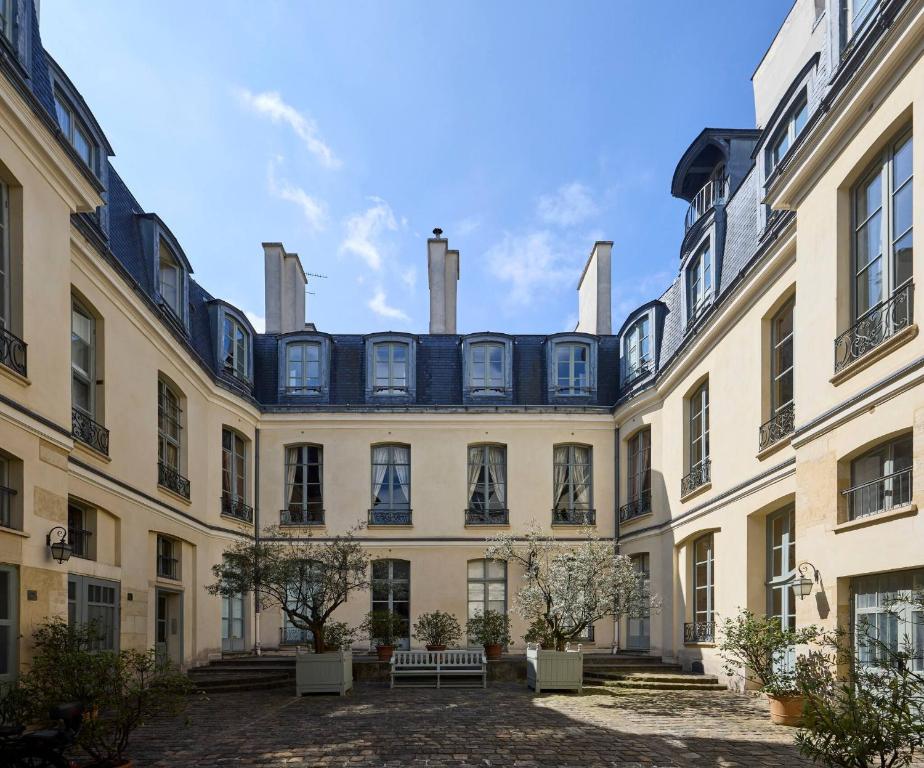 - une vue sur l'extérieur d'un grand bâtiment avec des fenêtres dans l'établissement Un 1-Ch/1-SdB Confortable- Place des Vosges, à Paris