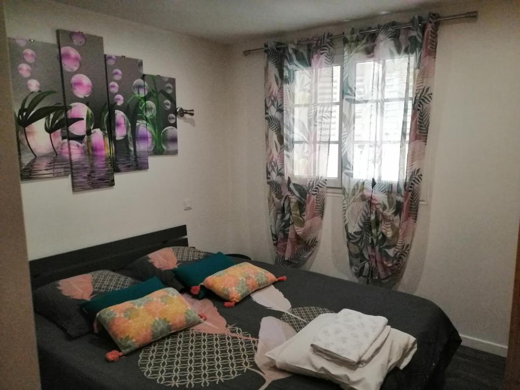 une chambre avec un lit et deux tableaux au mur dans l'établissement 2 Pièces ZEN dans villa en pleine nature, à Antibes