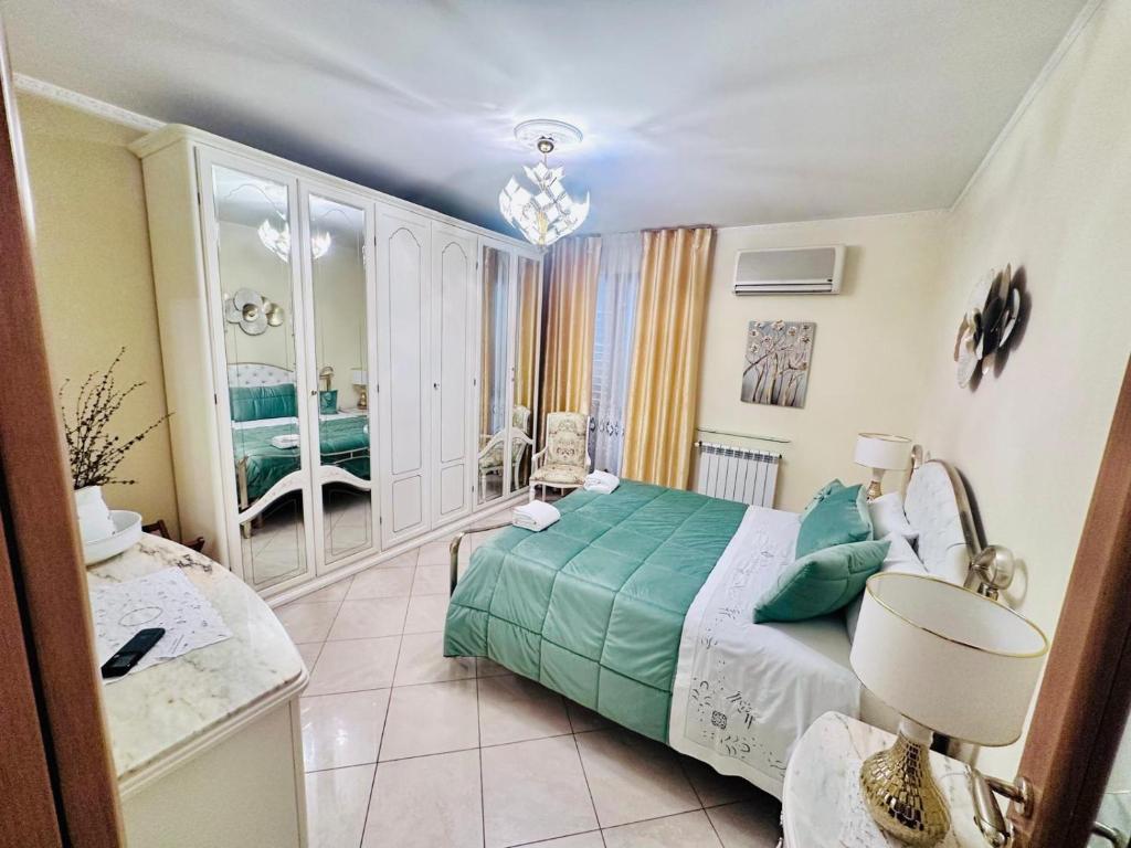 a bedroom with a green bed and a bathroom at Maison de Charme in Carlentini