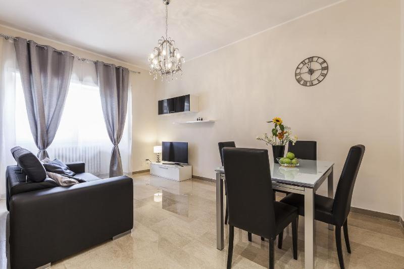 een woonkamer met een tafel, een bank en een klok bij Casa Tony in Rome
