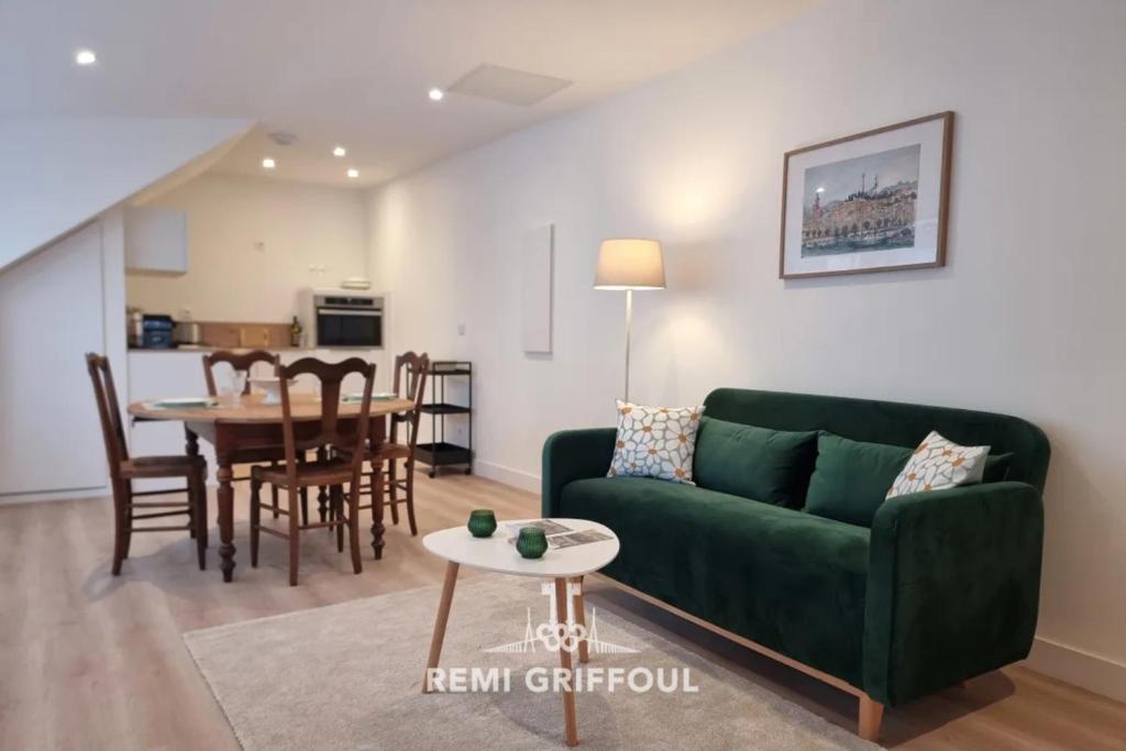 un salon avec un canapé vert et une table dans l'établissement Hypolite 5 Elegant Apartment 80 meters from Honfleur Port 2 guests, à Honfleur