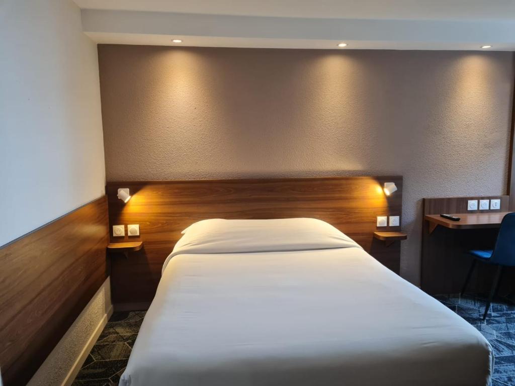 Postel nebo postele na pokoji v ubytování Hôtel Arcades