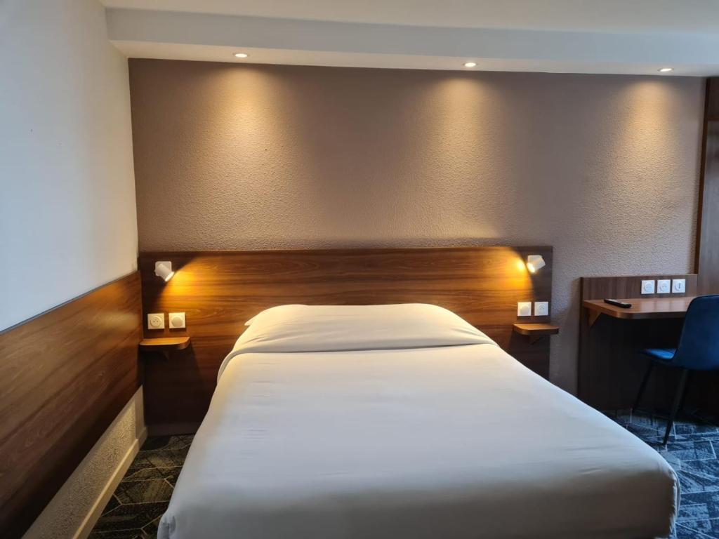 Postel nebo postele na pokoji v ubytování Hôtel Arcades