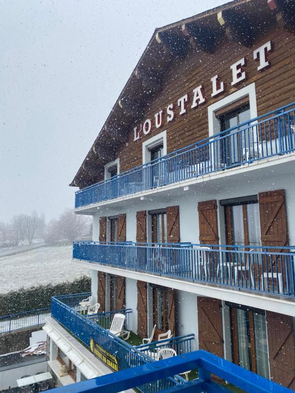 a building with snow falling on the roof at Hôtel L'Oustalet in Font Romeu Odeillo Via