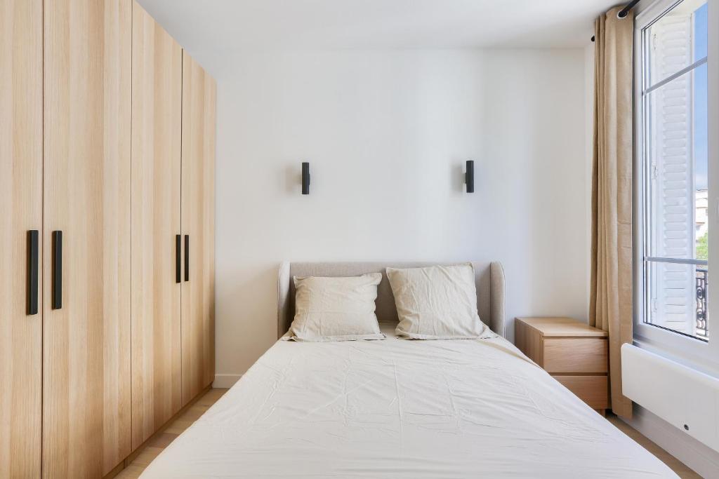 une chambre avec un lit et une fenêtre dans l'établissement Appartement 2 Pièces I 8 min à pied de la Défense, à Courbevoie