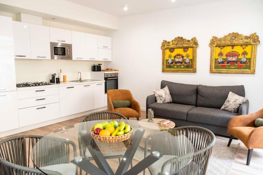 a kitchen and a living room with a glass table at Taormela 1 - Holiday Apartment in Taormina