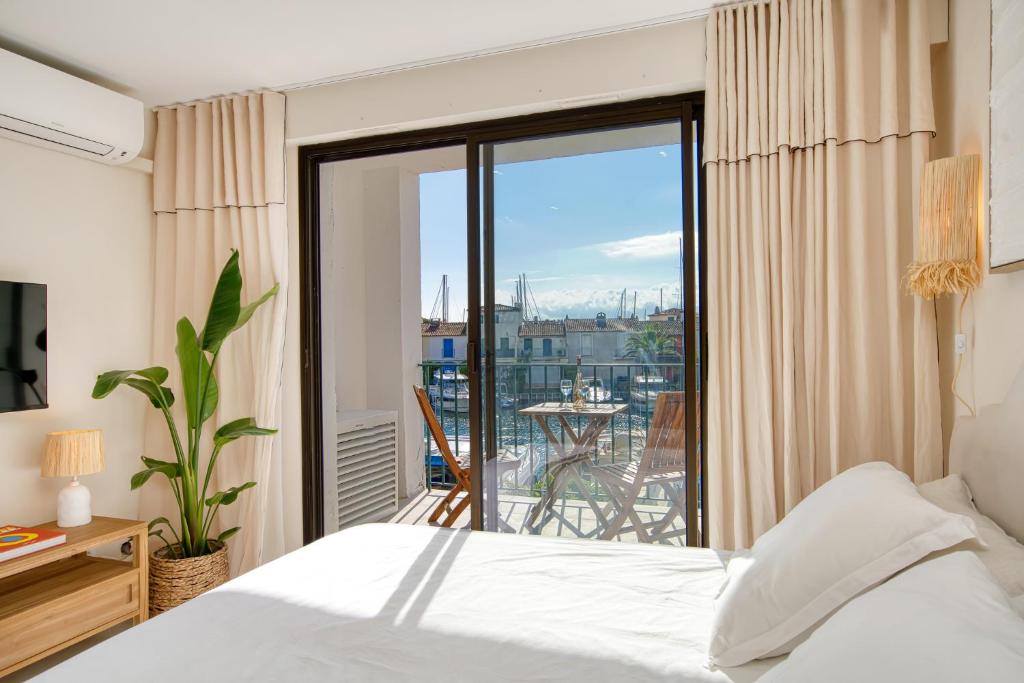 a bedroom with a bed and a view of a balcony at Studio rénové avec vue mer in Grimaud