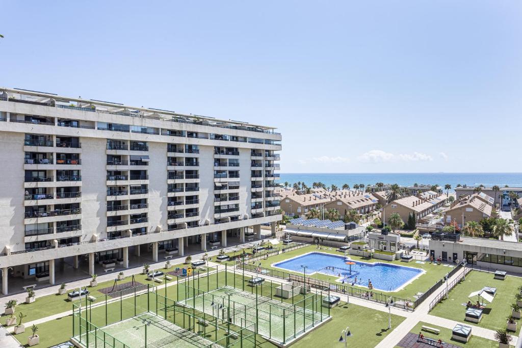 un grand bâtiment avec une piscine devant dans l'établissement Valencia Playa, à Valence