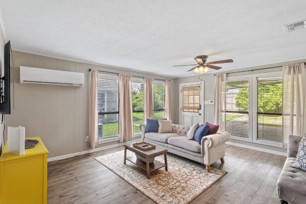 a living room with a couch and a ceiling fan at Downtown Cottage in Lake Charles