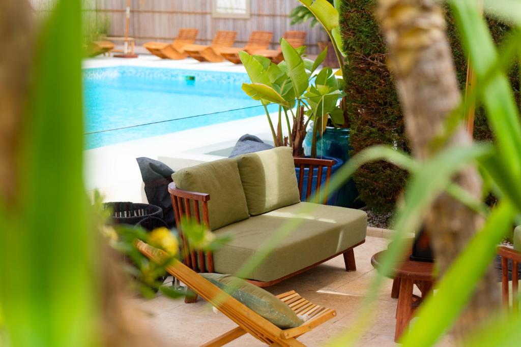 a green couch sitting next to a swimming pool at La Garoupe-Gardiole in Antibes