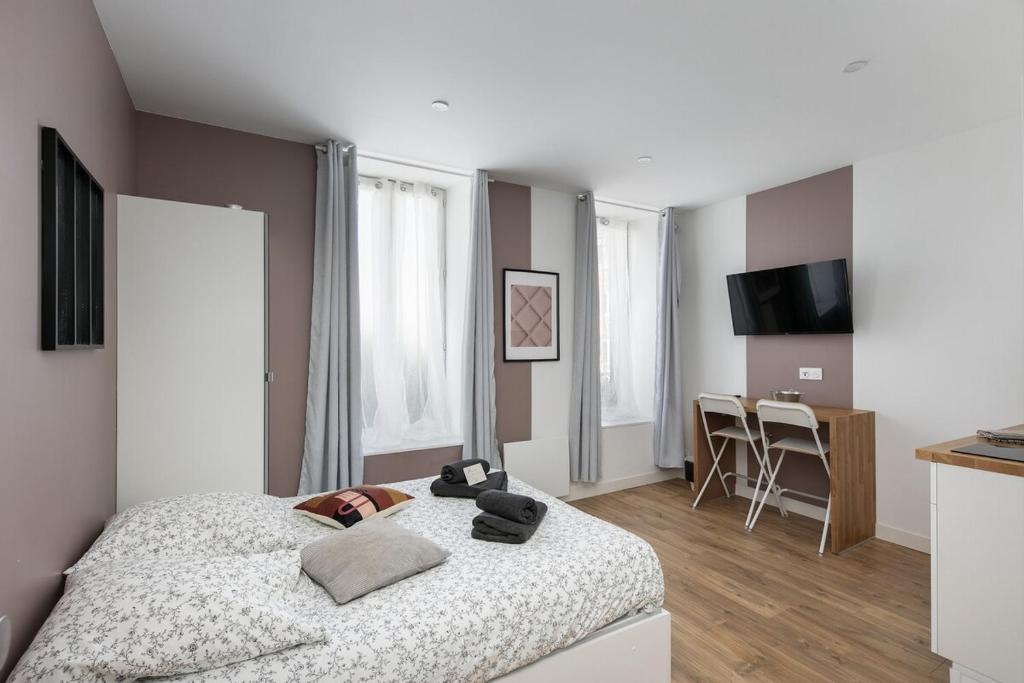 une chambre avec un lit et une table dedans dans l'établissement Pommeau, à Brest