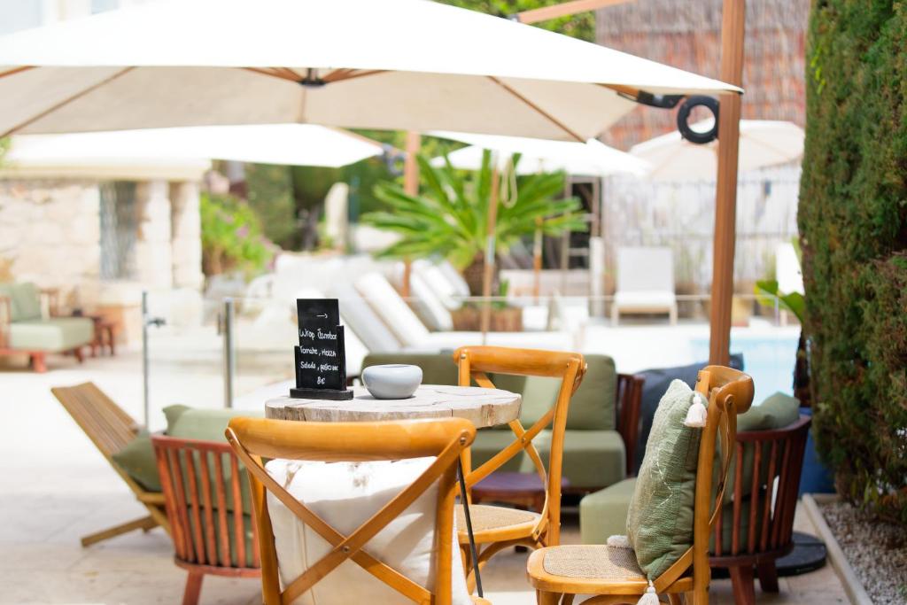 a table with chairs and an umbrella on a patio at La Garoupe-Gardiole in Antibes