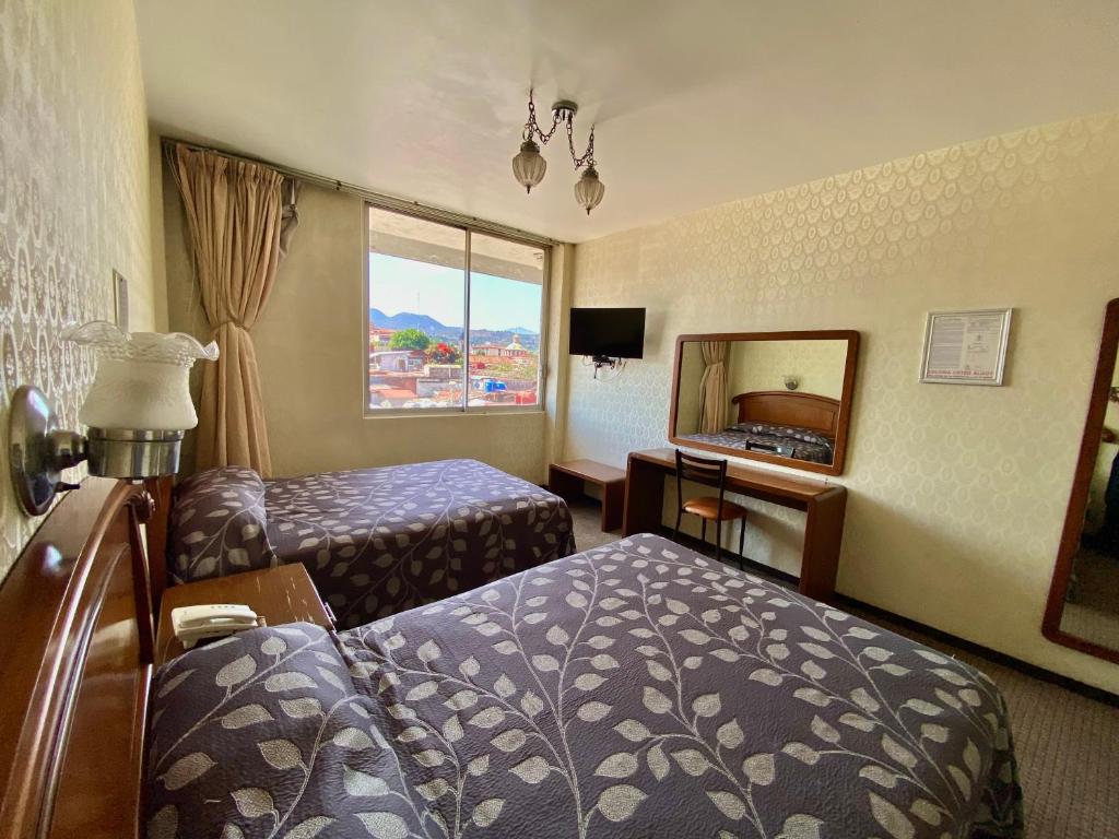 a hotel room with a bed and a mirror at Nuevo Hotel Alameda de Uruapan in Uruapan del Progreso