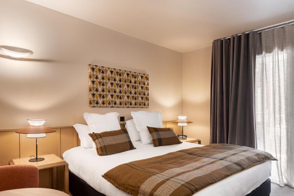 a hotel room with a bed and a window at Hôtel L'Adresse in Saint Malo