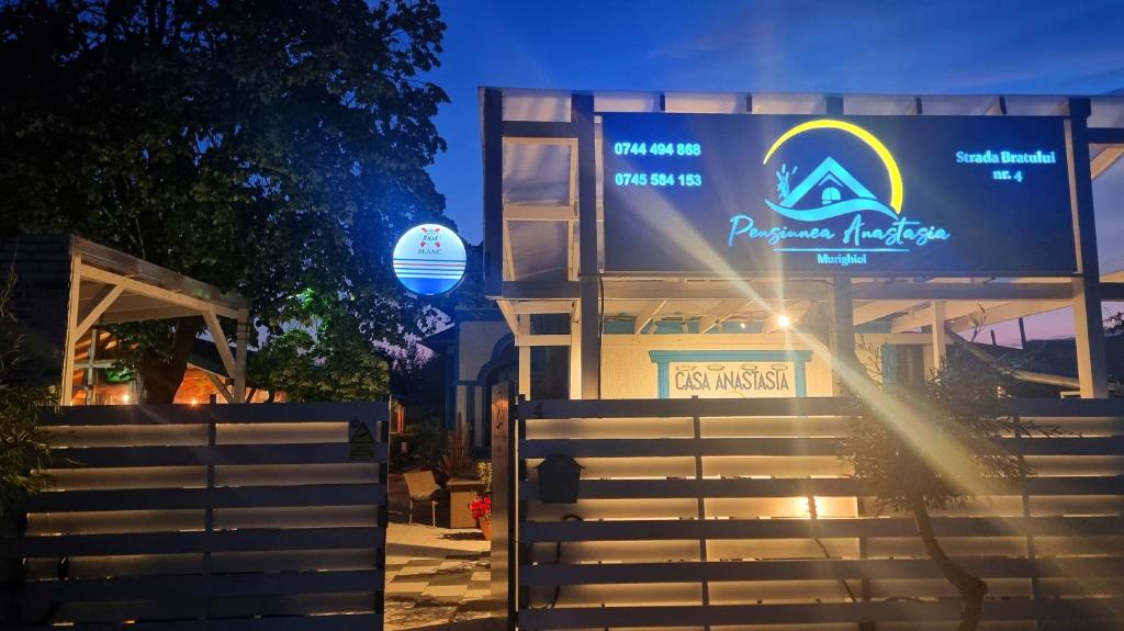 a sign in front of a building at night at Complex Turistic Casa Anastasia in Murighiol