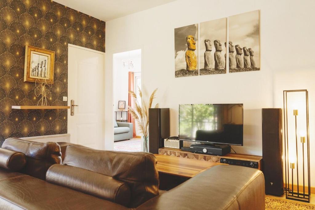 un salon avec un canapé en cuir et une télévision dans l'établissement Bright, vintage-style apartment, à Marseille