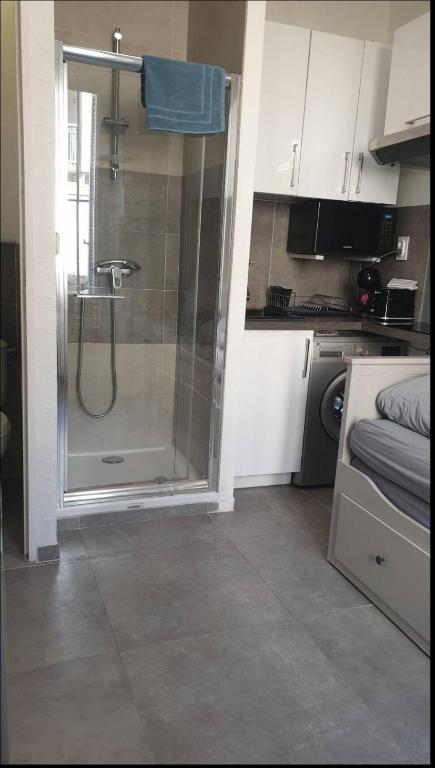 une salle de bain avec une douche avec une porte vitrée dans l'établissement Small Cocoon Marseillais, à Marseille