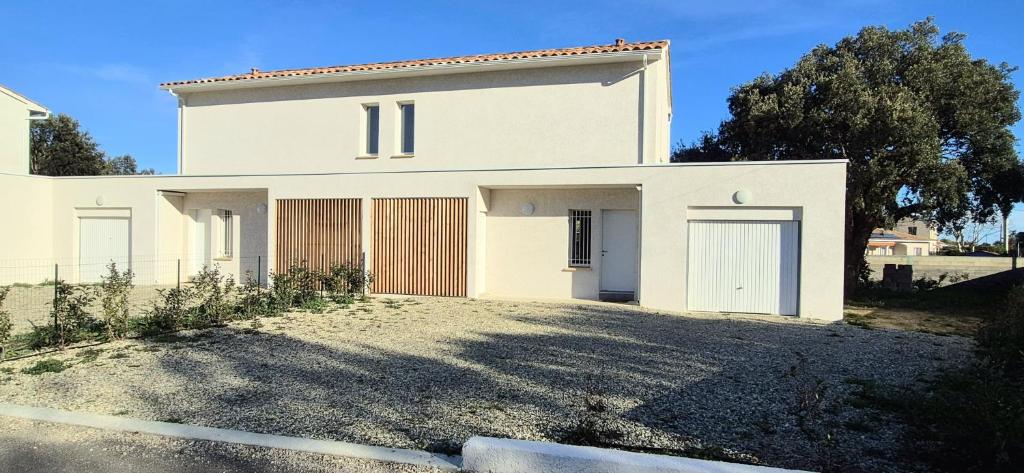une maison blanche avec une grande allée devant elle dans l'établissement Maison neuve 2024 avec jardin, à Prunelli-di-Fiumorbo
