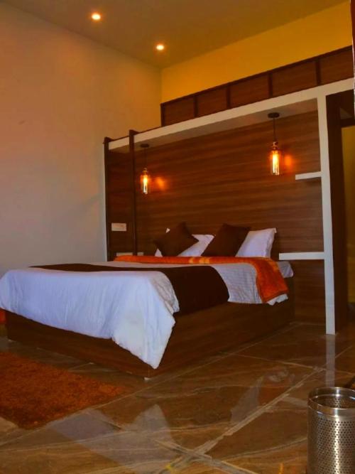 une chambre avec un grand lit avec une tête de lit en bois dans l'établissement BlackBuck Cottage, à Jyotirmath