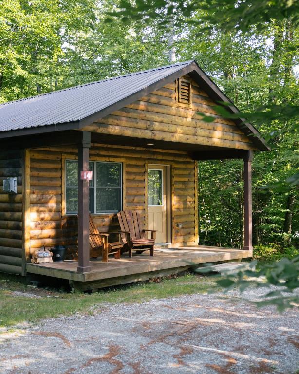 a log cabin with two chairs on a deck at Sterling Ridge Resort in Jeffersonville