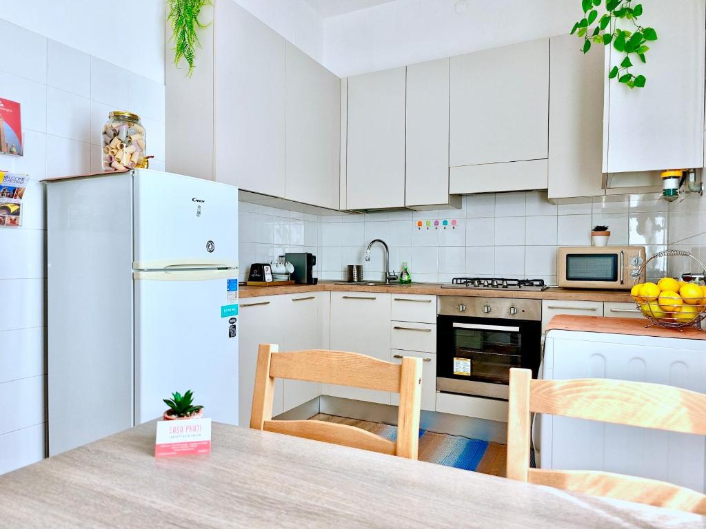 a kitchen with white cabinets and a table with chairs at Free Parking - No Tourist Tax - Motor Valley in Castelfranco Emilia