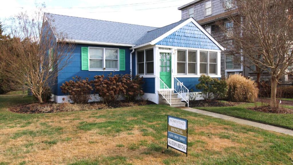 une maison bleue avec un panneau devant dans l'établissement 103 Broadway, à Cape May