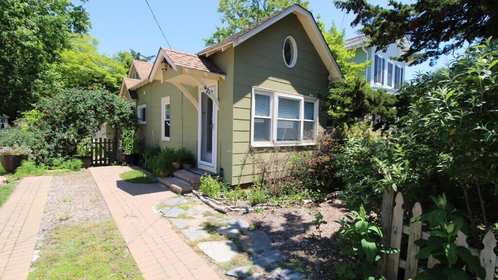 a small green house with a fence at Cottage On Cambridge in Cape May Point